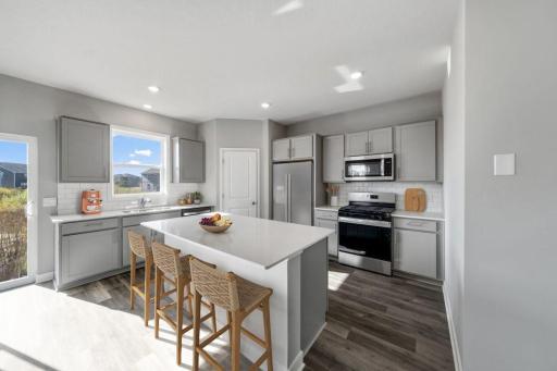 This home showcases a stunning backsplash complemented by elegant hardware. (Photo of model, colors are similar)