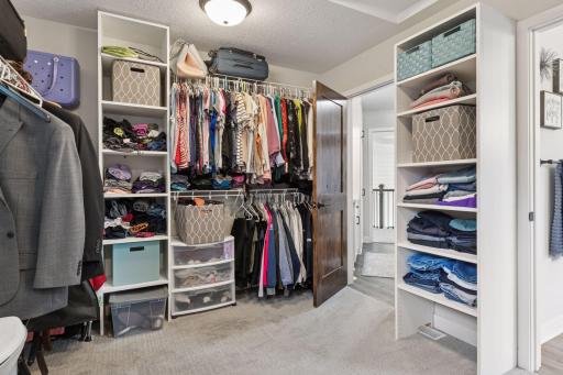 The expansive walk-in closet offers ample storage and convenient access to the laundry room, which can be closed off for added privacy.