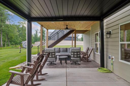 An additional patio area offers the perfect spot to unwind, all set beneath a built-in outdoor speaker system for ambient sound.