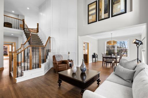 Grand living space featuring 2022 remodeled staircase and batten style feature wall, rich hardwood floors and welcoming main level layout.