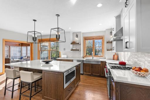 Bright, high-end kitchen with large Cambria island, custom cabinetry, Wolf Dual Fuel Gas Range, Wolf in-cabinet drawer microwave, Sub-Zero refrigerator, hardwood floors designed for daily living and entertaining. Remodeled 2022 by Murphy Bros.
