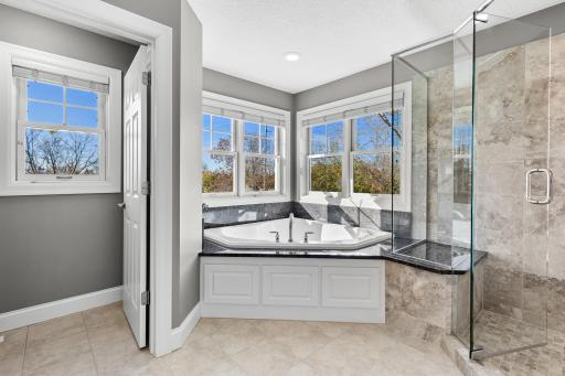 Spa like primary bathroom with soaking tub, glass enclosed walk-in shower, private toilet room, bright and airy layout designed for relaxation.