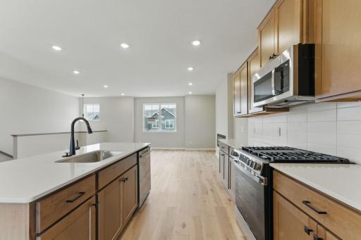 A centrally located, open kitchen becomes the heart of the home, keeping the family connected by providing easy access to family and dining.