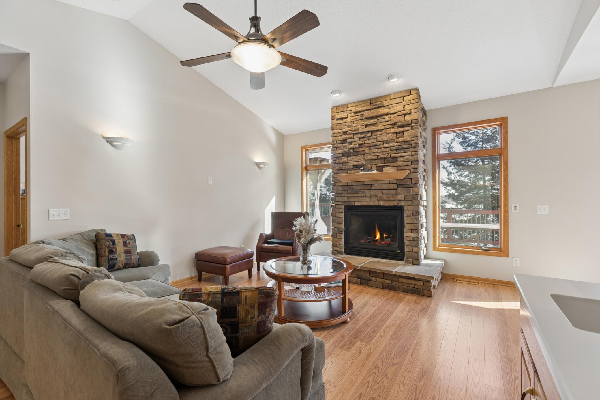 The main floor den is beautiful with the vaulted ceilings and gas fireplace with stone surround. The symmetry of the lakeside picture windows flanking the fireplace frames the room nicely.