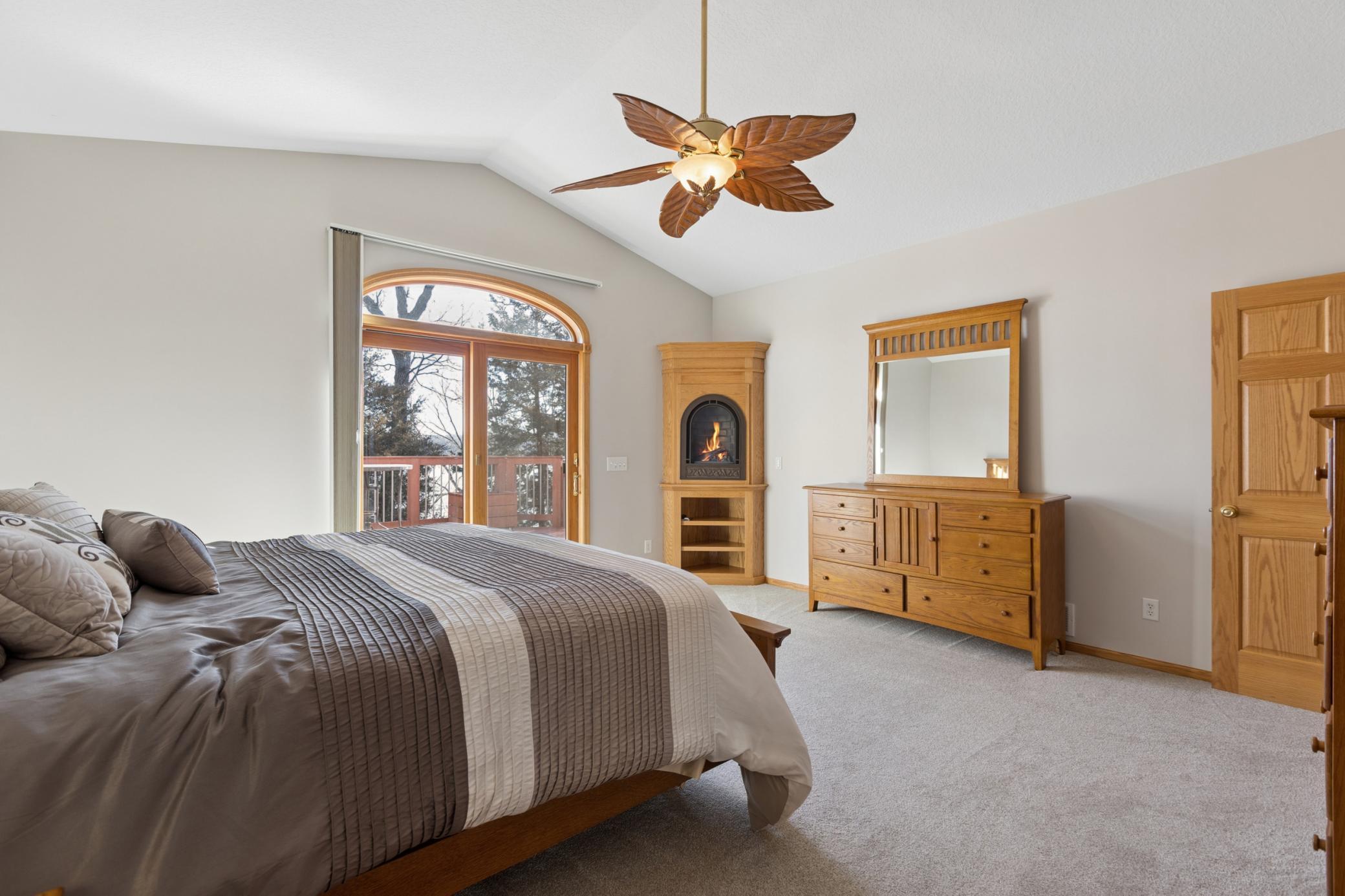 The primary bedroom suite features a gas burning corner fireplace, its own patio door leading out to the lakeside deck and a spacious ensuite bathroom with walk-in closet.