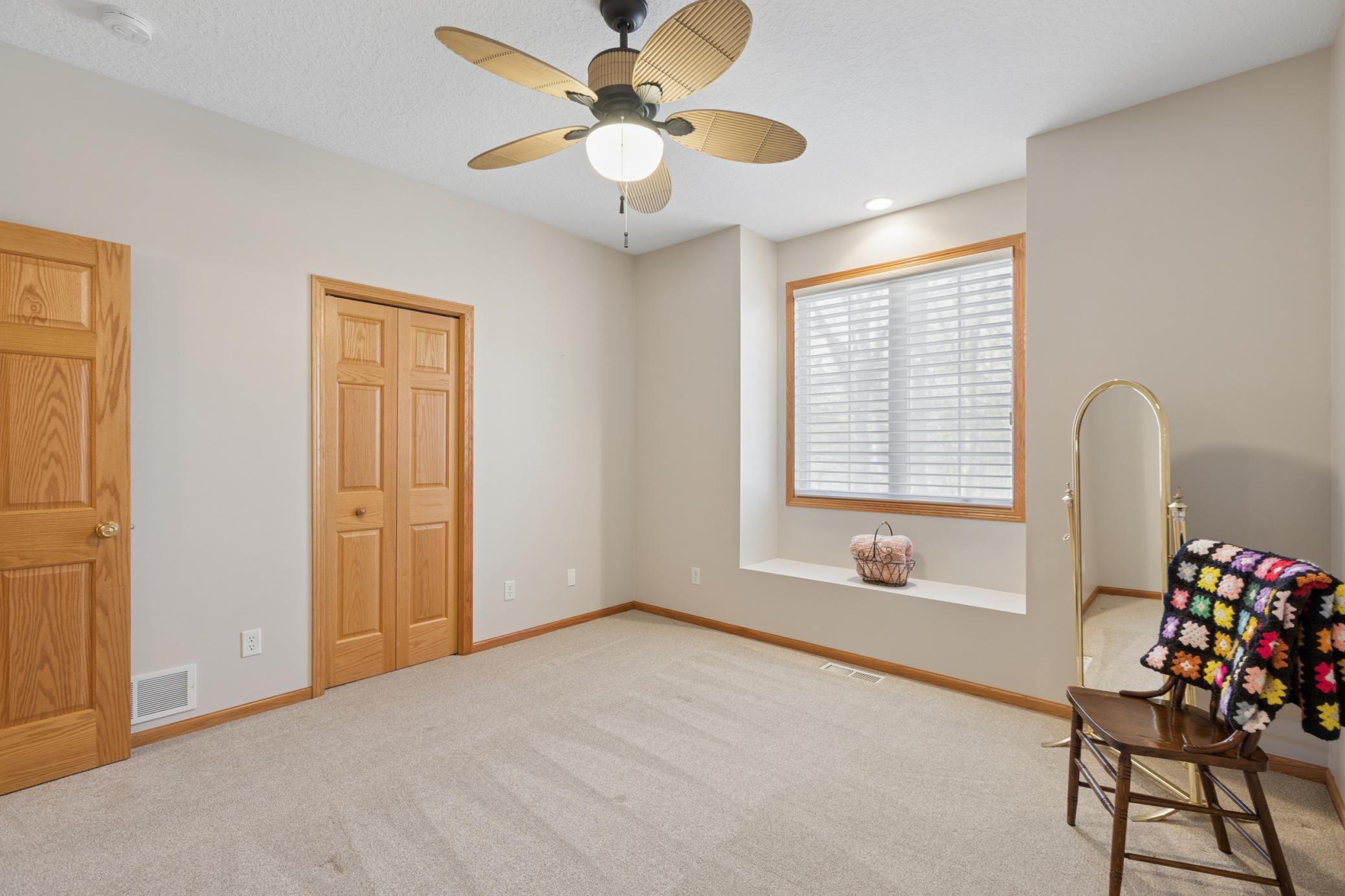View of the second main floor bedroom with nice sized closet, reading nook and a pass-through full bathroom with pocket door.