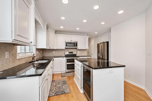 Updated kitchen with granite countertops, tile backsplash, center island, hardwood floors, wine refrigerator and breakfast bar!