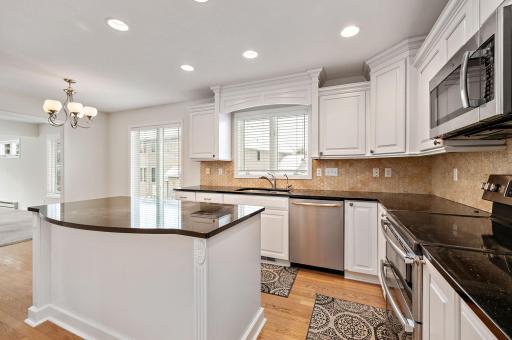 Updated kitchen with granite countertops, tile backsplash, center island, hardwood floors, wine refrigerator and breakfast bar!