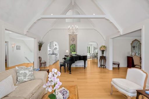 The living room opens to the dining room (on the right), and carries the repeated arch through the upstairs and arched openings into the kitchen/family room.