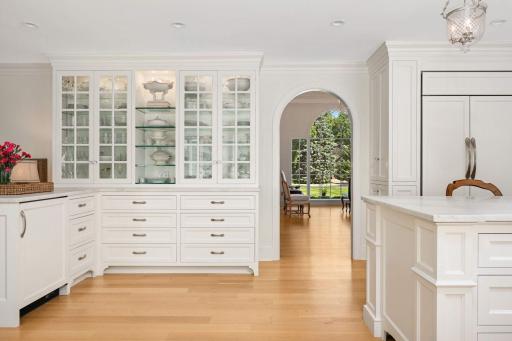 Arched design thoughtfully corresponds with one another. There is a beverage cooler just to the left of the lower cabinet doors.