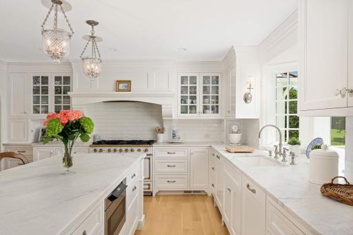 Behind the island is the pull out microwave, neatly stored, two dishwashers and beautiful lighting fixtures.