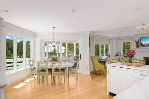 White oak runs throughout the living/entertaining spaces, and here the three season porch is off the informal dining area, which also steps down into the family room.