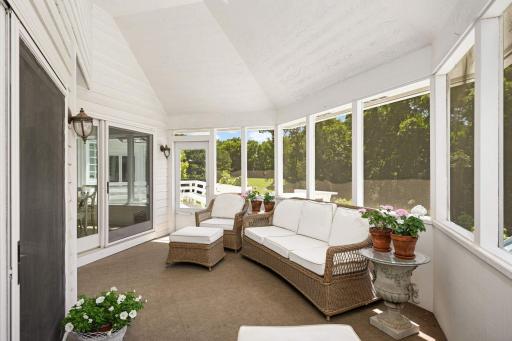 The three season porch has access to the deck, and overlooks the pool area and wooded acreage.