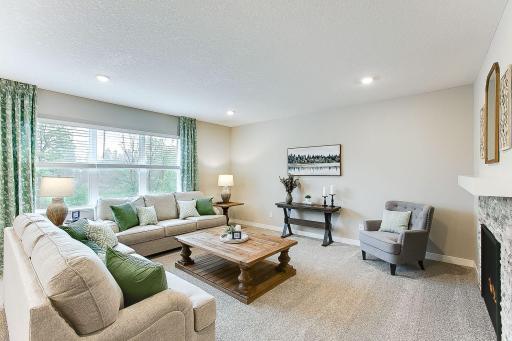 Enjoy the view of the backyard trees from your large living room windows! Photo of model home, colors and finishes will vary.