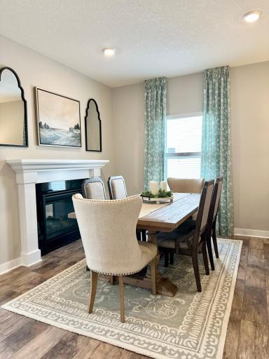 Dining or flex room space, you decide! Imagine a warm, cozy dinner party or game night! Dual sided gas fireplace will also have a travertine stone surround. Photo of model home, colors and finishes will vary.