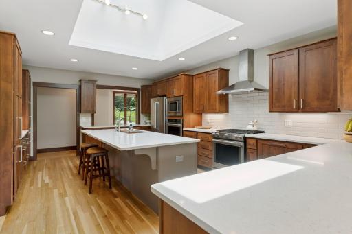 The large center island features a breakfast bar for quick meals, snacks, or homework, while also serving as the perfect spot for appetizers, desserts, or cocktails when guests arrive.