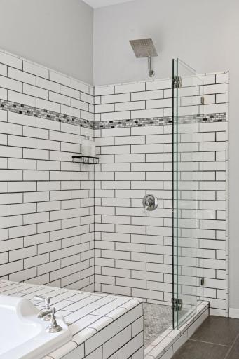 The large walk-in shower, finished with custom tile, adds both comfort and style to a space that works just as well on a Monday morning as it does on a Sunday evening.