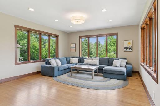 This main level family room blends bright, open living with peaceful viewsâopen to the kitchen and wrapped in windows overlooking the backyard.