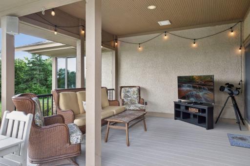 The covered porch, anchored by a wood-burning fireplace, flows effortlessly onto the decks for indoor-outdoor living and relaxing evenings.