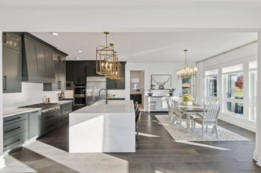 The gourmet kitchen is a showstopper complete with high-end appliances, an oversized island, quartz countertops, and elegant brass lighting fixtures.
