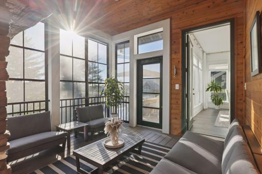 With access to both the expansive outdoor deck and kitchen, the screened porch with fireplace, Eze-Breeze windows, and wood-paneled ceiling overlooks lush fairways, greens, and sunset views.