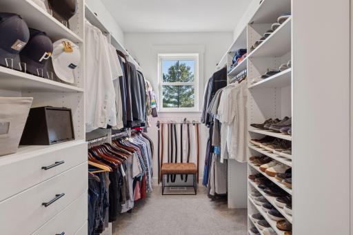 The primary walk-In closet with custom shelving for meticulous organization makes getting ready a breeze!
