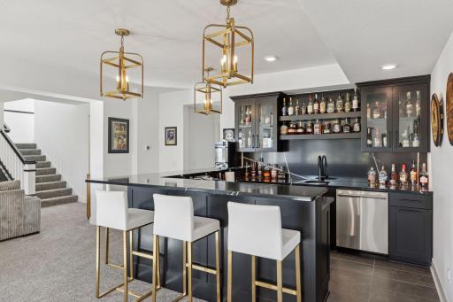 The designer details continue throughout the lower level with an entertainment area that rivals a private club complete with a custom wet bar, gaming space, and access to the beautifully landscaped backyard.