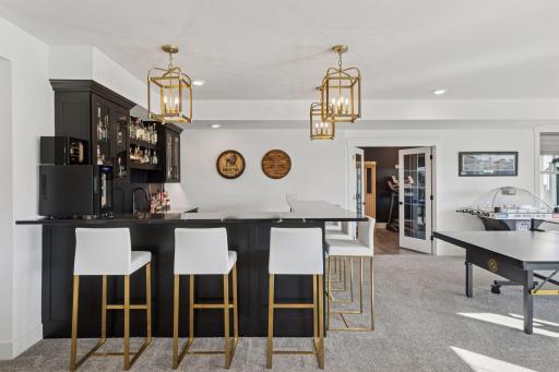 The designer details continue throughout the lower level with an entertainment area that rivals a private club complete with a custom wet bar, gaming space, and access to the beautifully landscaped backyard.