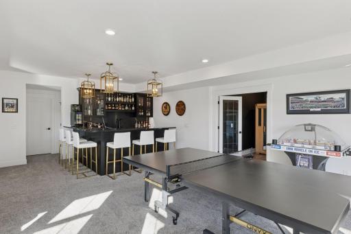 The designer details continue throughout the lower level with an entertainment area that rivals a private club complete with a custom wet bar, gaming space, and access to the beautifully landscaped backyard.