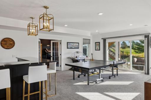 The designer details continue throughout the lower level with an entertainment area that rivals a private club complete with a custom wet bar, gaming space, and access to the beautifully landscaped backyard.
