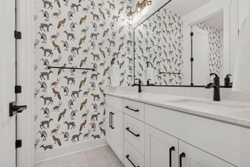 Modern designs enhance the upper level bathroom. Dual sinks and privacy door separating the sinks and shower area make busy mornings a breeze!