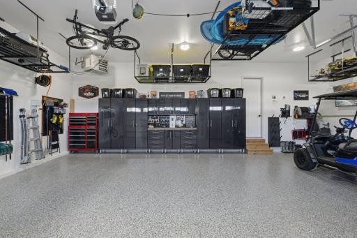 The oversized three-car heated garage is more than a place to park; it's a pristine extension of the home finished with epoxy flooring, professional storage systems, and a dedicated golf cart bay for effortless access to the course.