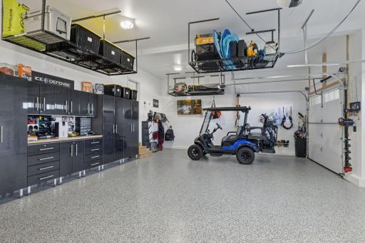 The oversized three-car heated garage is more than a place to park; it's a pristine extension of the home finished with epoxy flooring, professional storage systems, 220 volt outlet, and a dedicated golf cart bay for effortless access to the course!