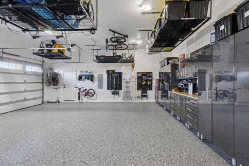 The oversized three-car heated garage is more than a place to park; it's a pristine extension of the home finished with epoxy flooring, professional storage systems, 220 volt outlet, and a dedicated golf cart bay for effortless access to the course!