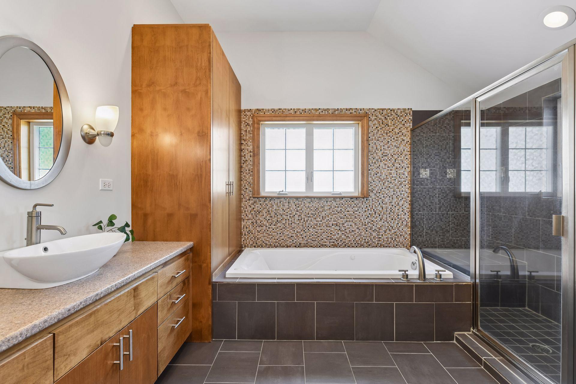 Primary suite bathroom with soaking tub, separate vanities.