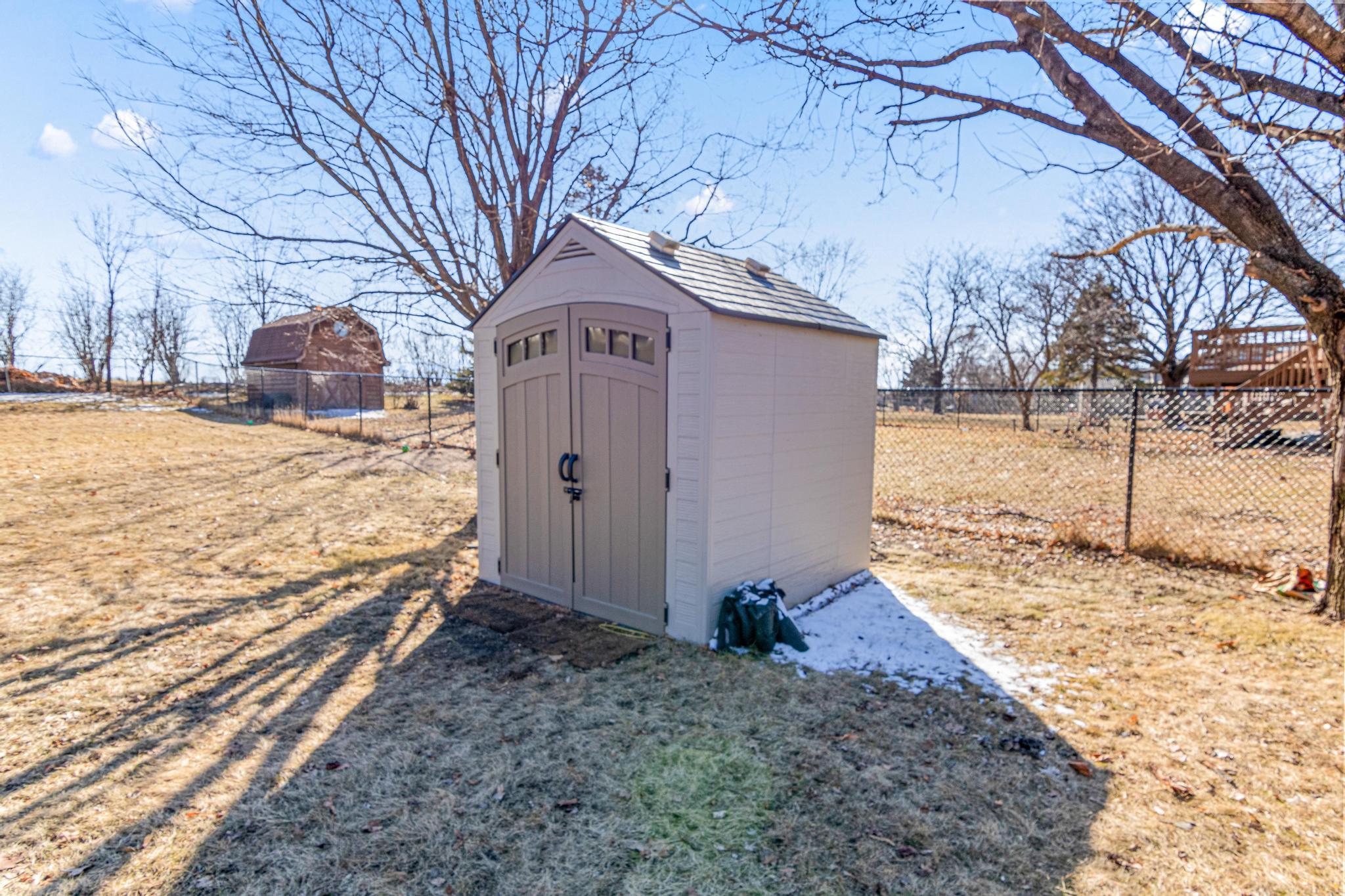 Fully fenced yard with shed.