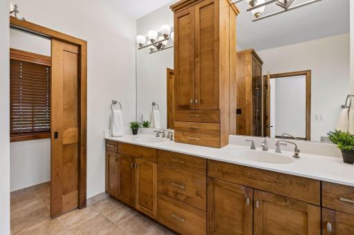 The spa-like primary bath offers dual sinks, a custom vanity tower for extra storage, heated floors, a jetted tub and separate shower. A perfect blend of functionality and elegance.