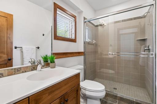 Lower level 3/4 bath with tile shower and flooring.