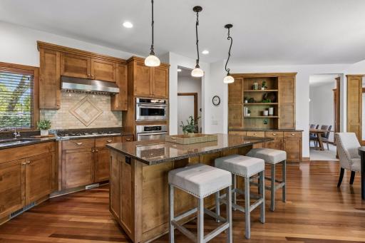 Beautifully appointed gourmet kitchen featuring granite countertops, hardwood floors, stainless steel appliances, and a spacious center island perfect for gathering and entertaining.