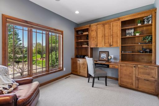 Main floor den with custom built-ins and recessed lighting.