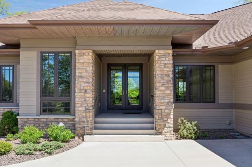 Beautiful covered entry showcasing durable cement board siding, elegant stone accents, and welcoming curb appeal with timeless architectural design.