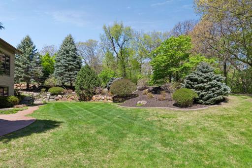 Situated on one of the most beautiful lots in the development, this exceptional setting showcases mature oak & aspen trees along with extensive professional landscaping, including rock boulder walls, concrete edging, and landscape lighting.