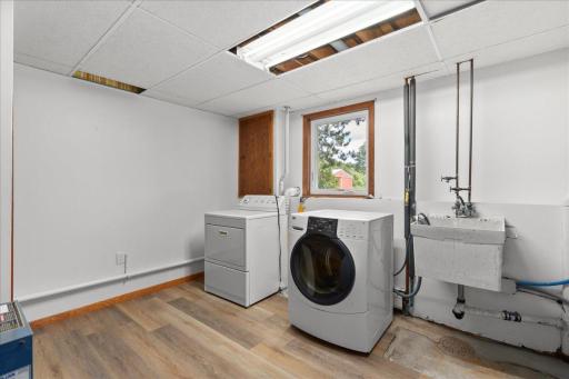 Lower level laundry room with sink and additional storage space.