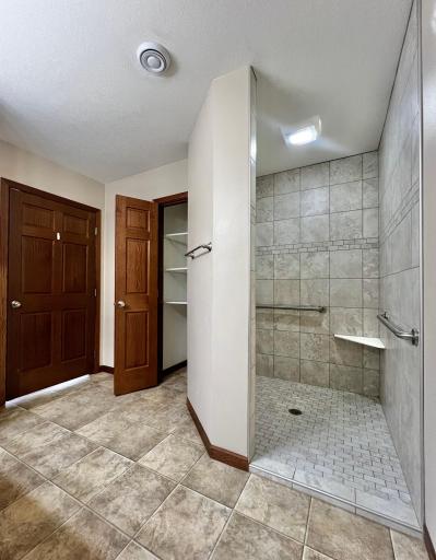 Spacious Tiled Shower with Grab Bars and Shelves!