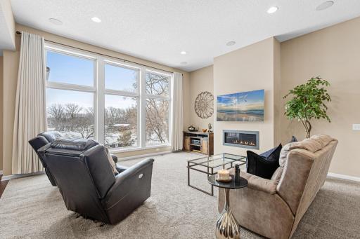 11-foot ceiling and floor-to-ceiling Andersen windows with a gas fireplace serving as the focal point highlight the main level Living Room.