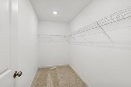 (Photo is of a model home, finishes will vary) The walk-in closet with built-in shelving provides ample room for growing wardrobes