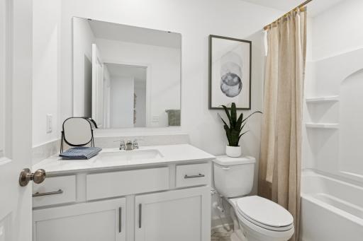 (Photo is of a model home, finishes will vary) A full bathroom on the second floor comes well-equipped with a stylish vanity and a combination shower and tub.