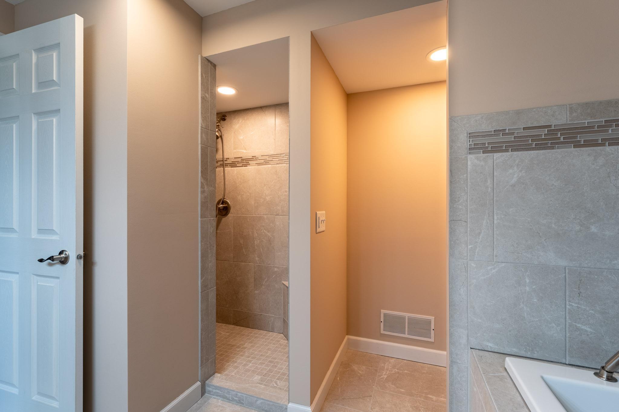 Newer Full Bathroom in the Lower Level, features a separate tub, walk-in shower, and double vanity.