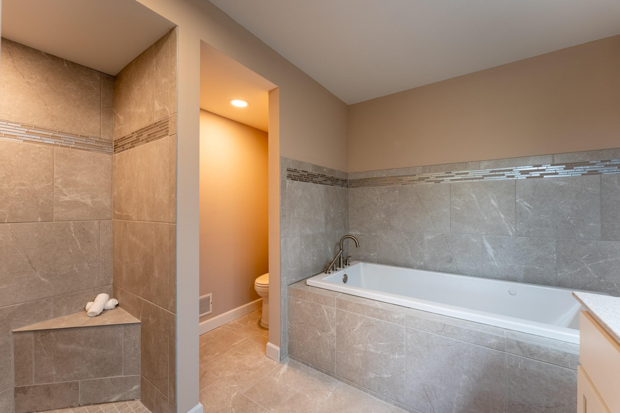 Newer Full Bathroom in the Lower Level, features a separate tub, walk-in shower, and double vanity.