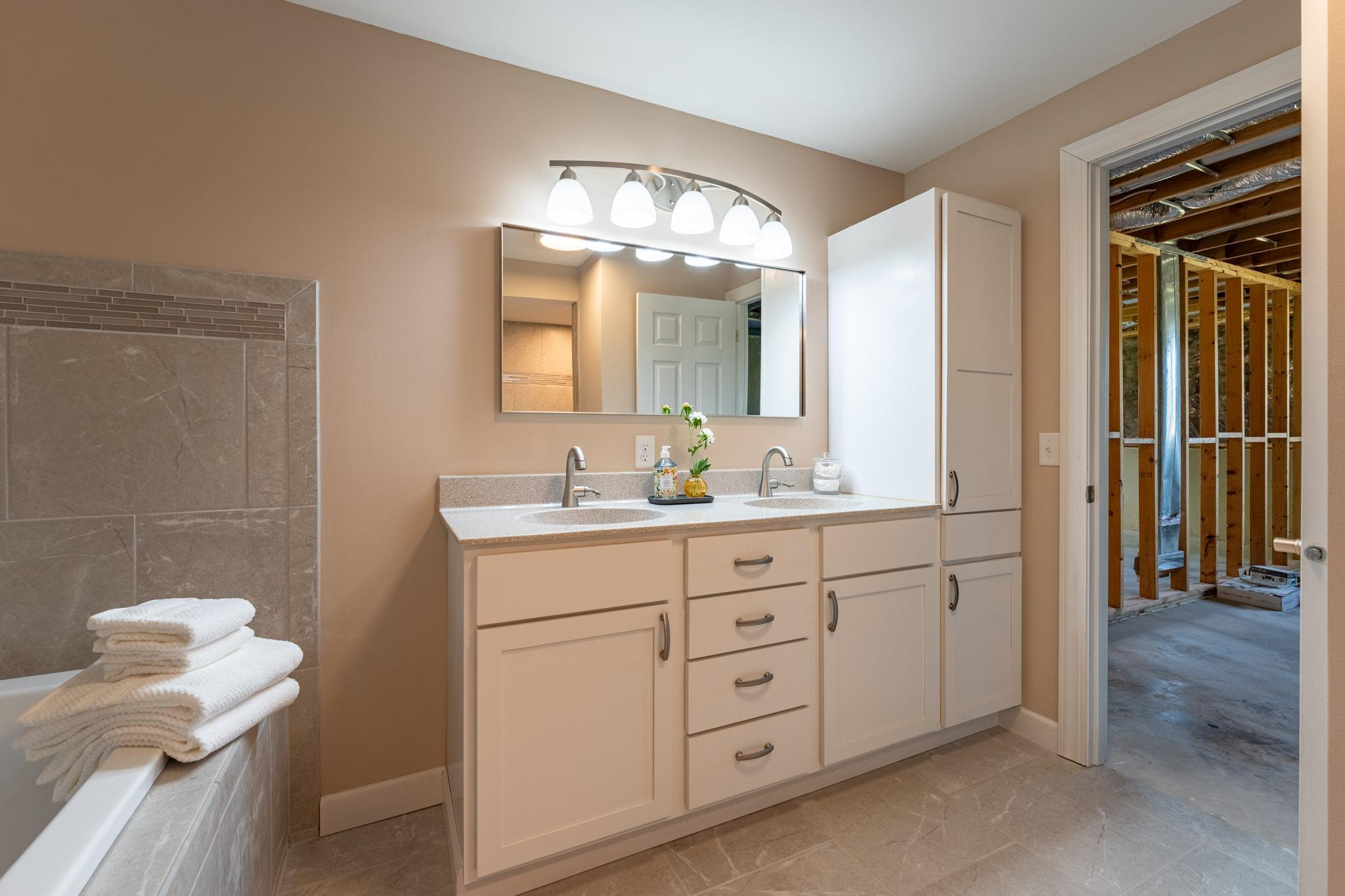 Newer Full Bathroom in the Lower Level, features a separate tub, walk-in shower, and double vanity.